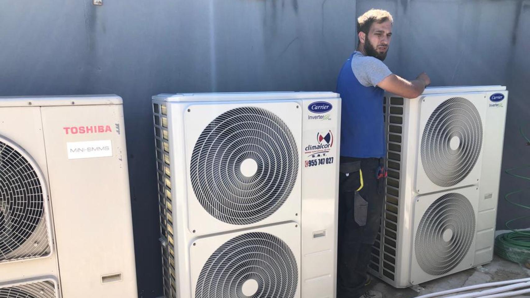 Uno de los operarios instala un aire acondicionado en Sevilla.