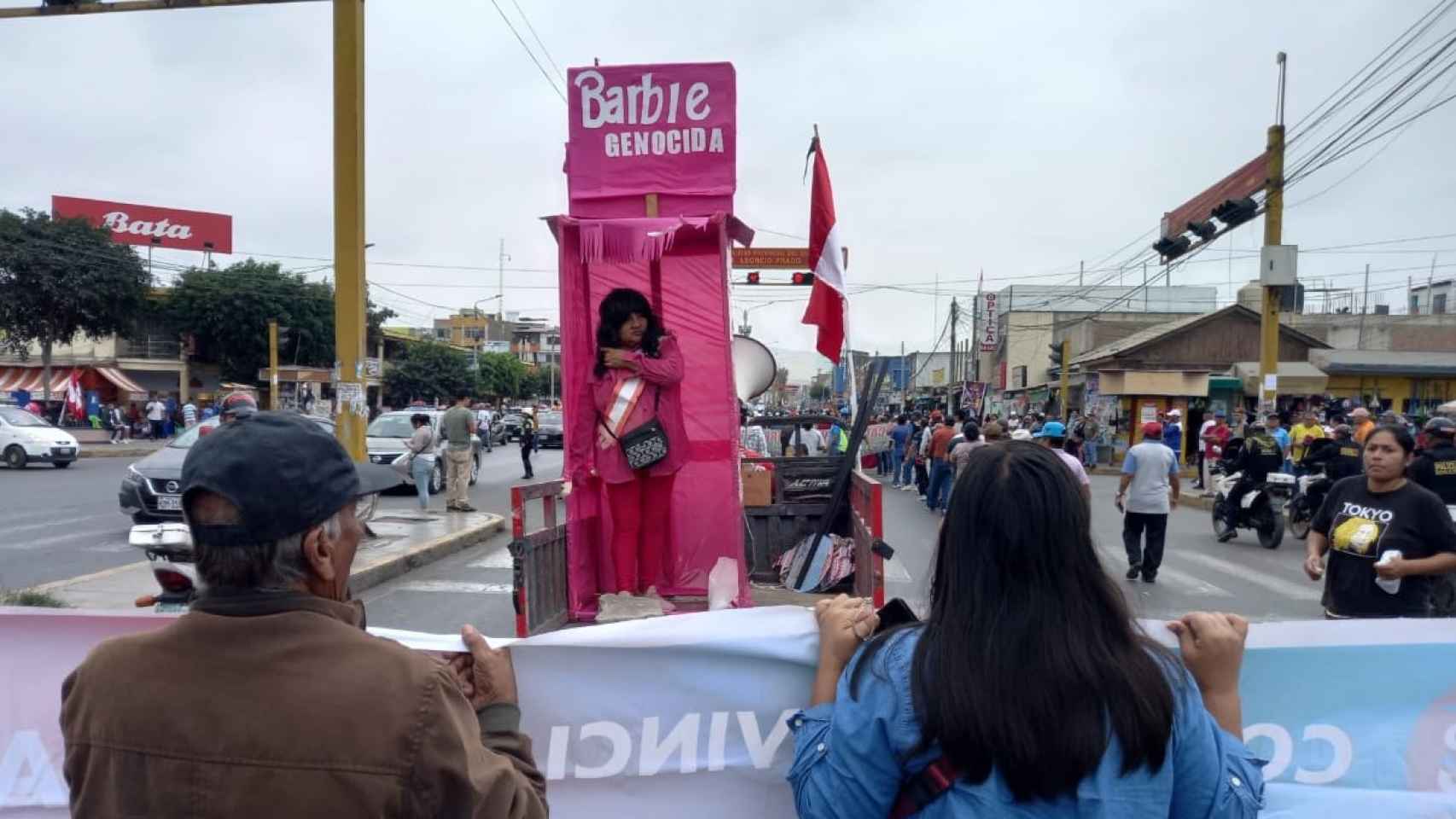 Una manifestante acude a las protestas difrazada de Dina Boluarte como la 'Barbie Genocida'.