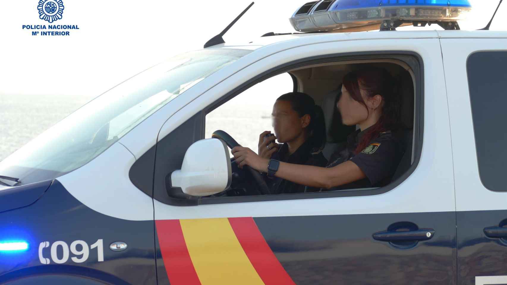 Dos agentes en servicio dentro de un vehículo policial.