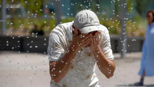 Un hombre trata de refrescarse del intenso calor.