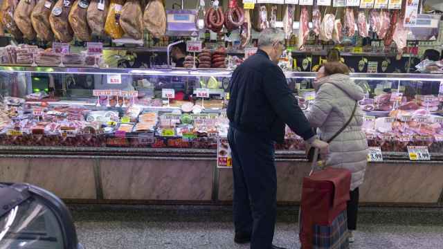 Una pareja compra en una charcutería en un mercado.