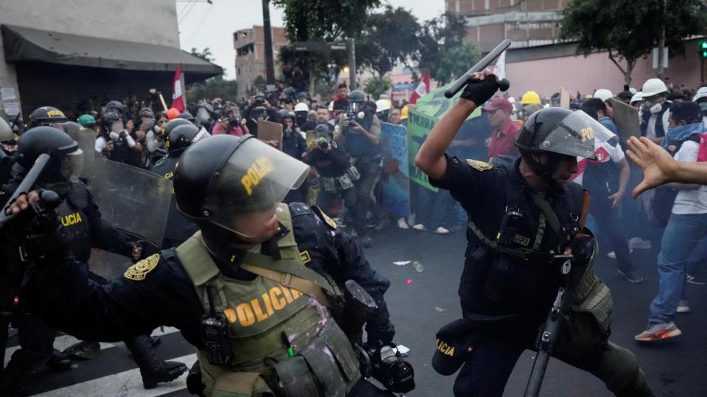 Policías antidisturbios cargan contra los manifestantes antigubernamentales, en Lima.