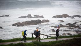 Varios peregrinos realizan el Camino de Santiago, a pesar del temporal, en la zona de Santa Maria de Oia hasta Cabo Silleiro, a 20 de octubre de 2022, en Pontevedra, Galicia, (España).