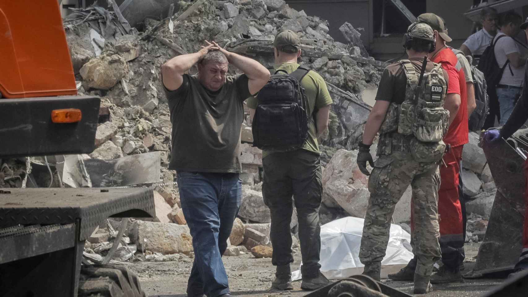 Un hombre llora la pérdida al lado de los restos mortales de su hijo en un edificio dañado en Odesa tras un bombardeo ruso.