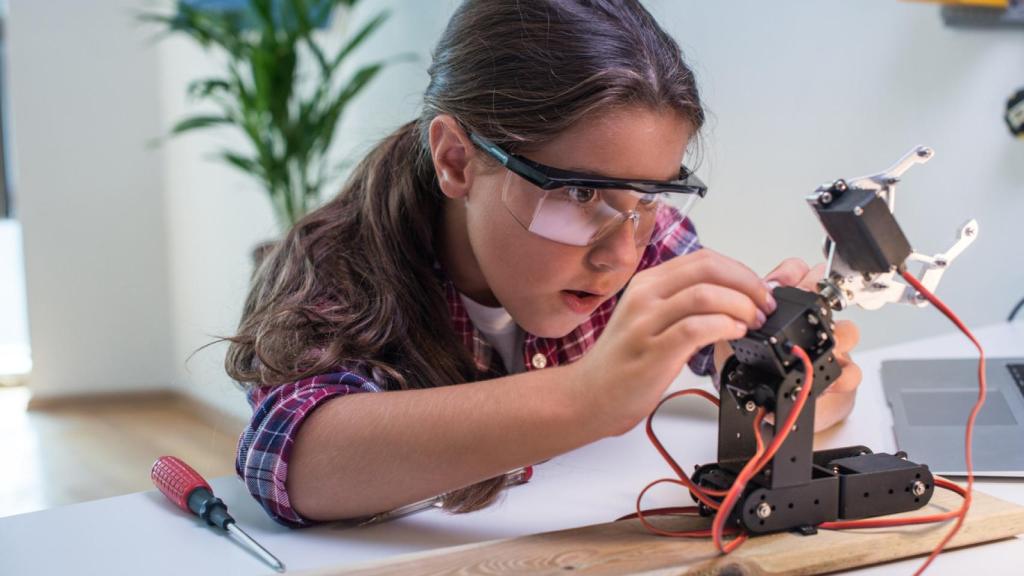 Un niña construyendo un robot.