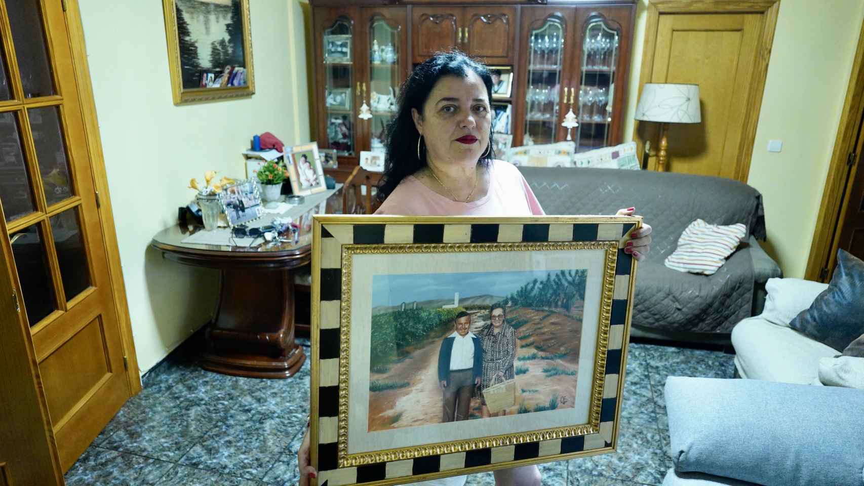 Mari Carmen López, junto a un retrato de sus padres adoptivos.