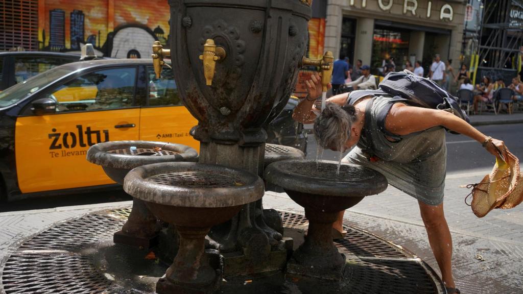 Una turista se refresca en una fuente en Barcelona, el 19 de julio de 2023, en plena ola de calor. Bruna Casas Reuters