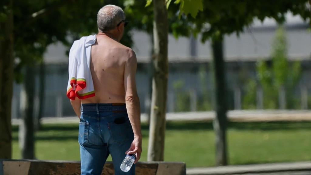 Un hombre paseando por la calle sin camiseta.