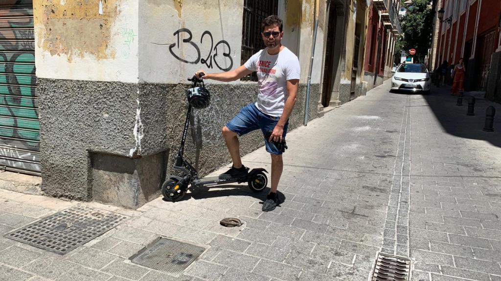 Alejandro, este martes, posando junto a la arqueta de la calle Varela de Granada donde sufrió el accidente en patín eléctrico.