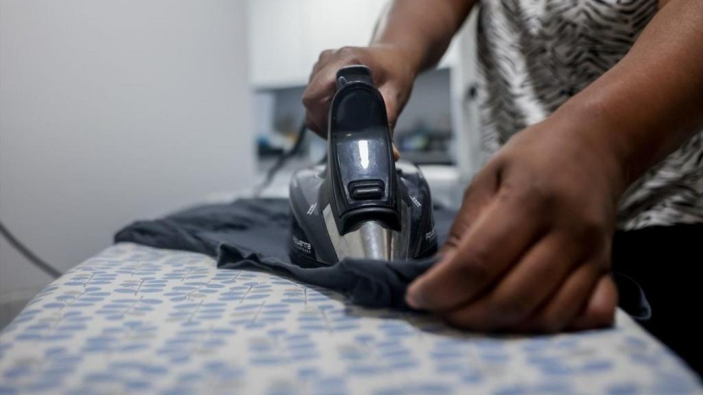 Una mujer planchando una camiseta.