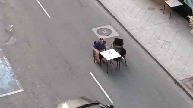 Vídeo de un hombre tomando algo en medio de la carretera.