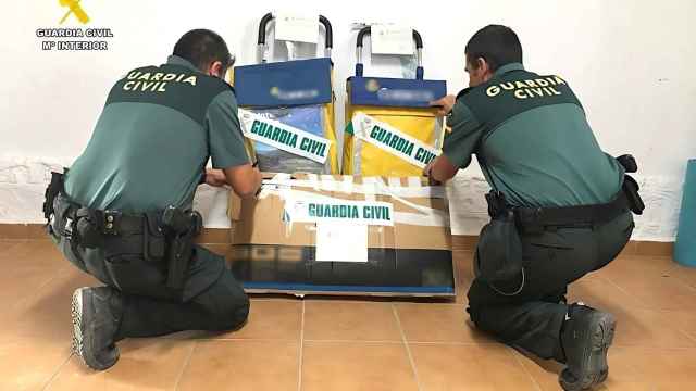 Los agentes de la Guardia Civil de Alicante con los dos carros encontrados con la correspondencia.