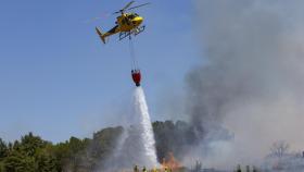Un helicóptero luchando contra el fuego en imagen de archivo