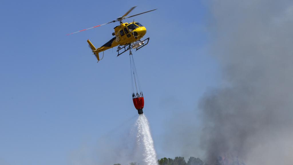 Un helicóptero luchando contra el fuego en imagen de archivo