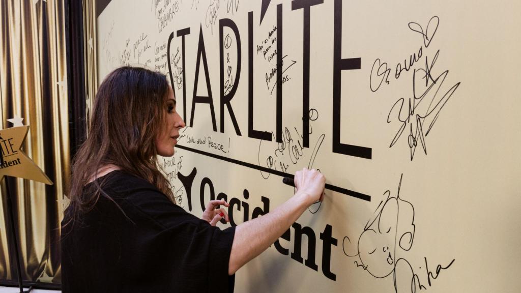 Malú firmando en una suerte de photocall, en Marbella.