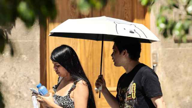 Una pareja se protege del sol con un paraguas esta semana en Valencia.