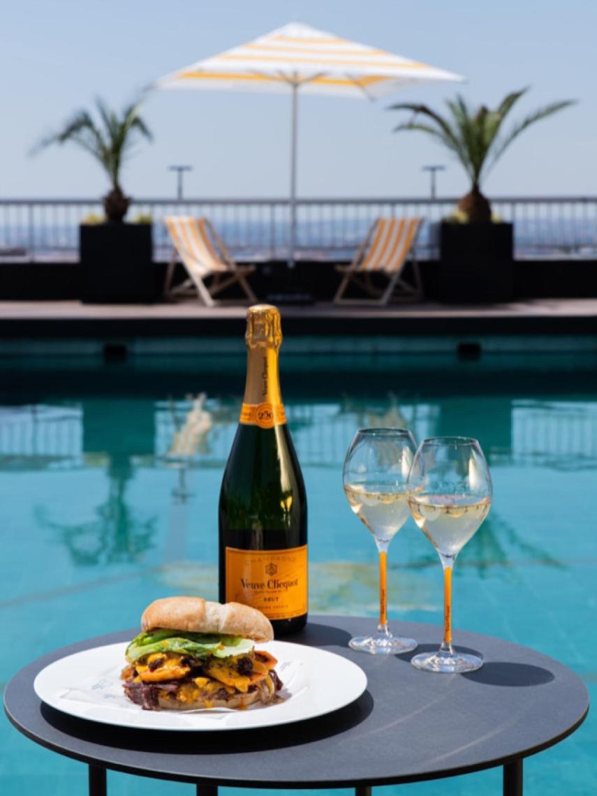 Veuve Clicquot más la burger con la piscina del Club Financiero Génova de fondo.