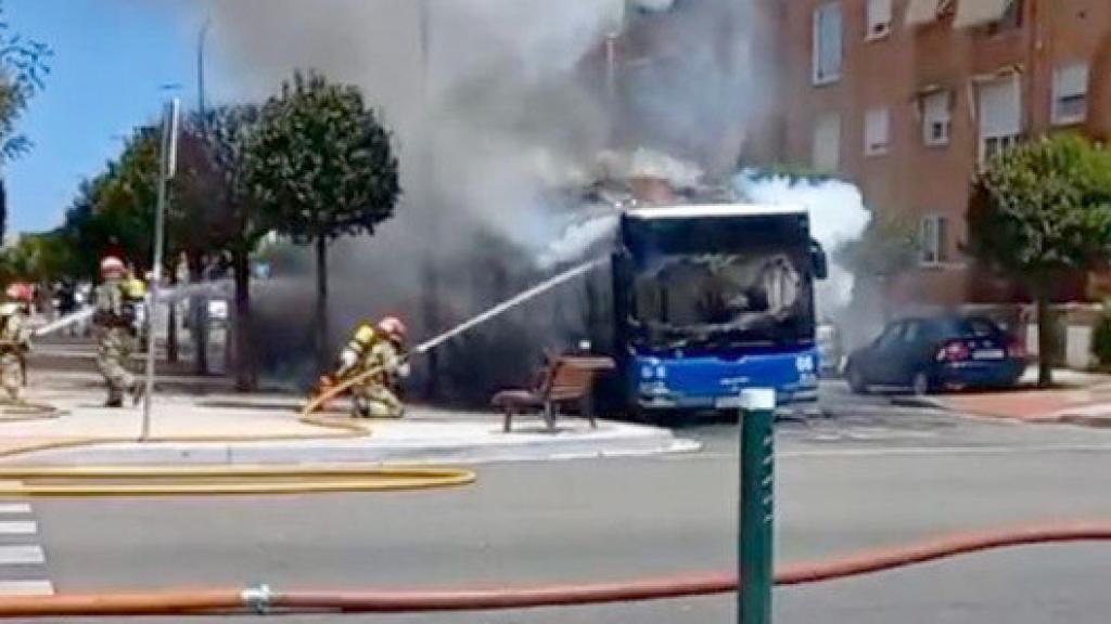 Los bomberos sofocando las llamas en el autobús