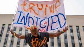Una manifestante sostiene una pancarta frente al tribunal federal donde se ha imputado a Trump, el martes.