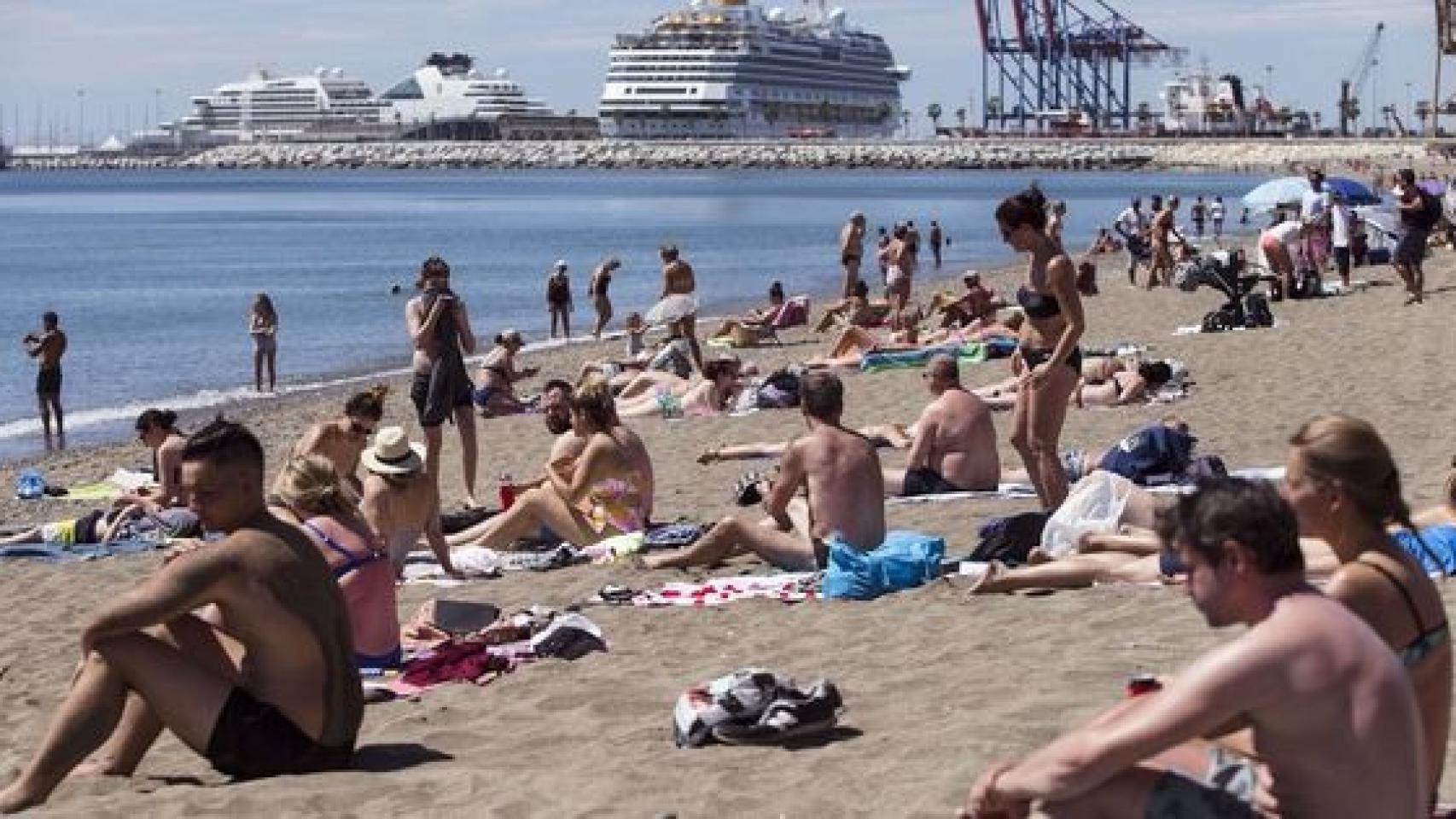 Varias personas tomando el sol en una playa de España.