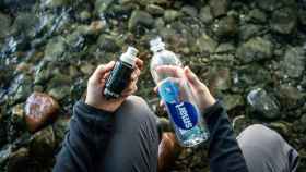 Una persona con el filtro y una botella de agua en un río.