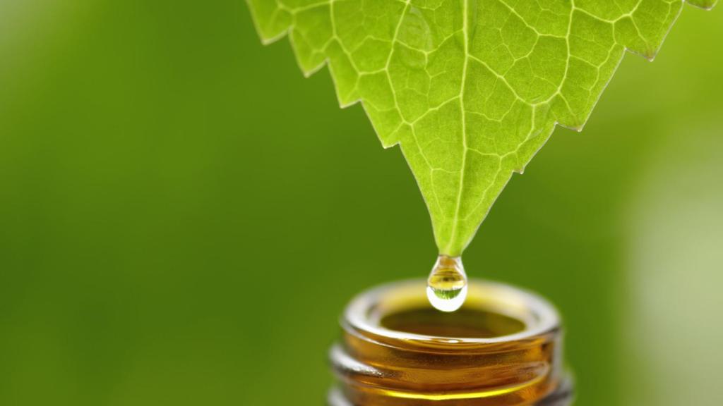 Una gota de aceite esencial cayendo a un bote de cristal.