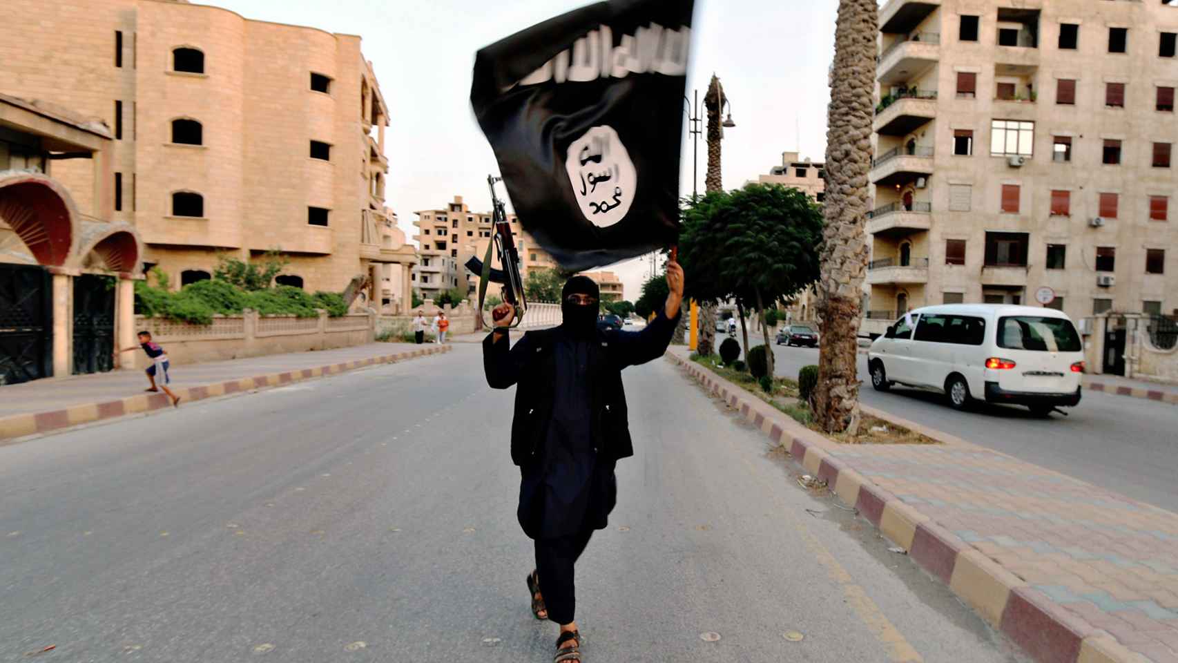Un combatiente de Estado Islámico porta la bandera de la organización terrorista.