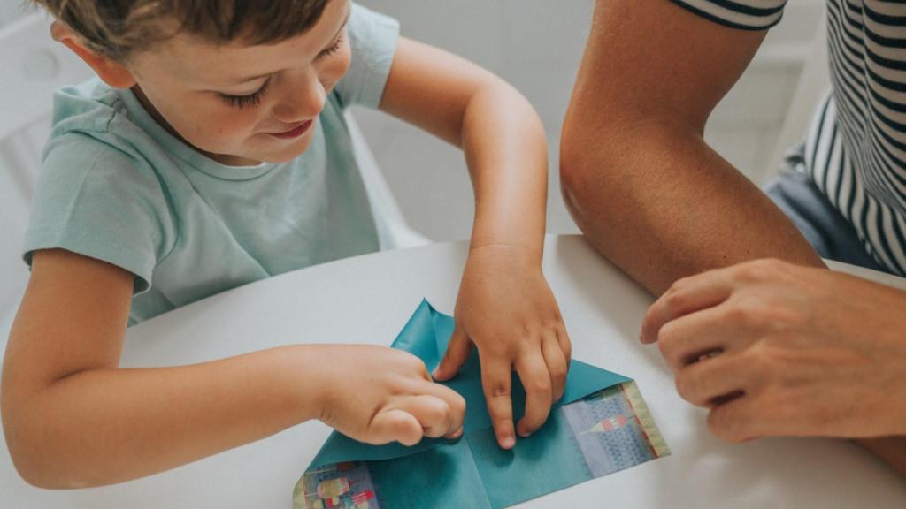 Un niño haciendo un avión de papel