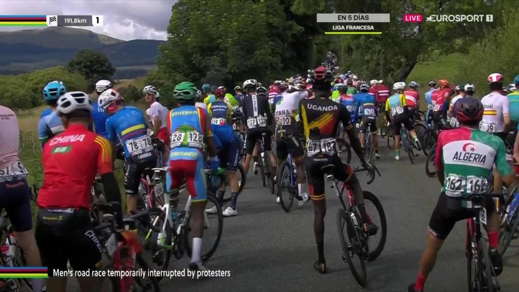 Los ciclistas aguardan en la carretera a la espera de que se reanude la carrera.