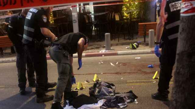 Agentes israelíes inspecciona la escena del crimen del policía, en Tel Aviv.