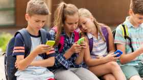 Un grupo de niños con teléfonos móviles.
