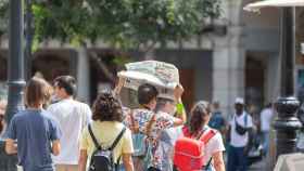 Un turista se protege del sol con un periódico en la plaza de Zocodover (Toledo). Javier Longobardo