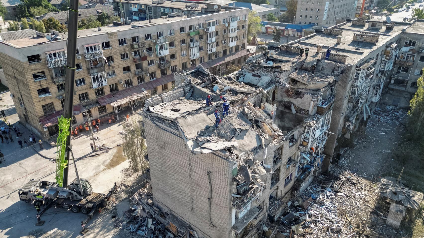 Los rescatistas trabajan con maquinaria pesada, en el sitio de un edificio destruido durante un ataque con misiles rusos, en medio del ataque de Rusia a Ucrania, en Pokrovsk.
