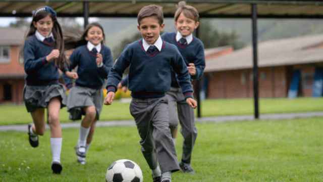 Niños y niñas jugando al fútbol en el patio del colegio