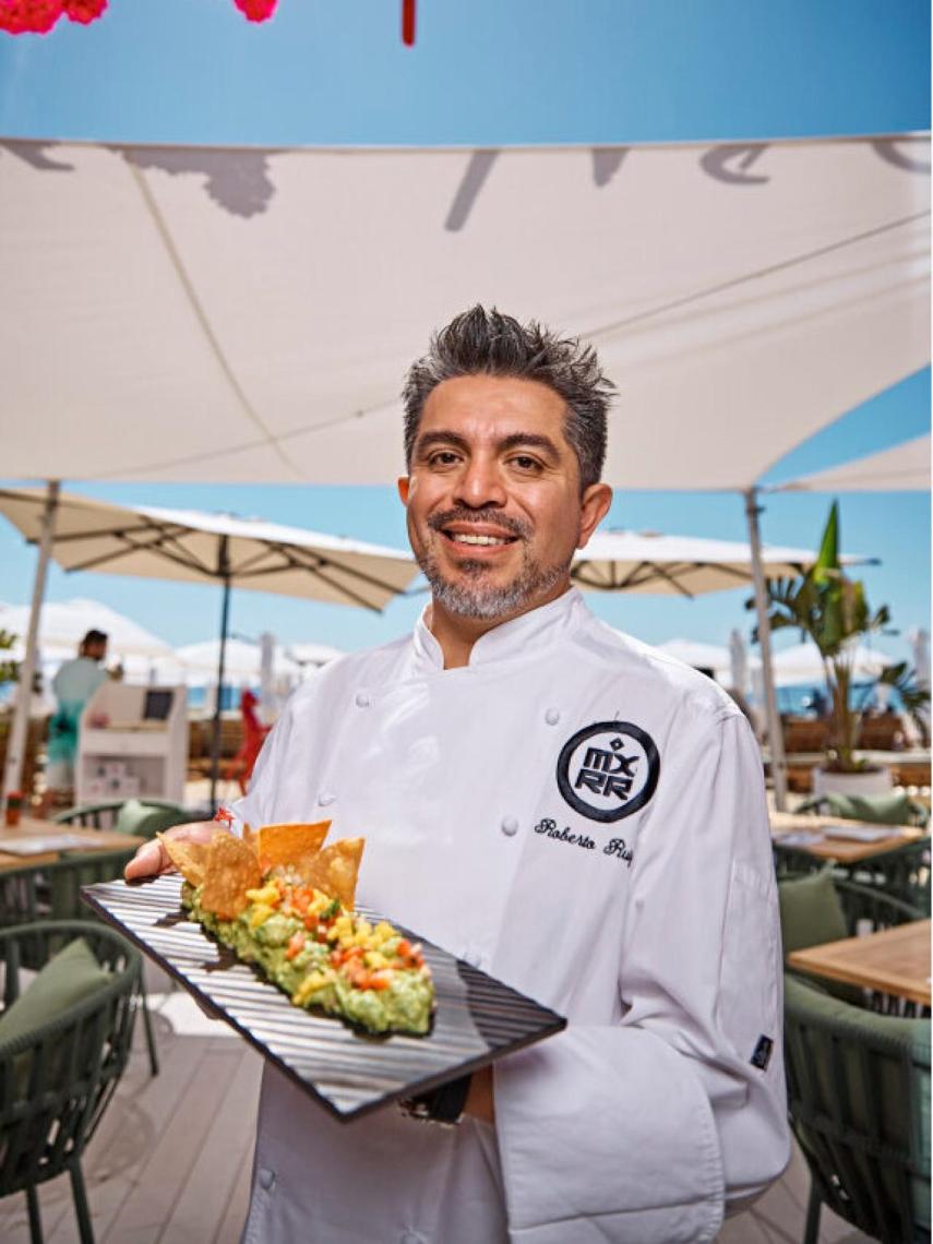 El chef Roberto Ruiz con un plato de nachos y guacamole con langostinos