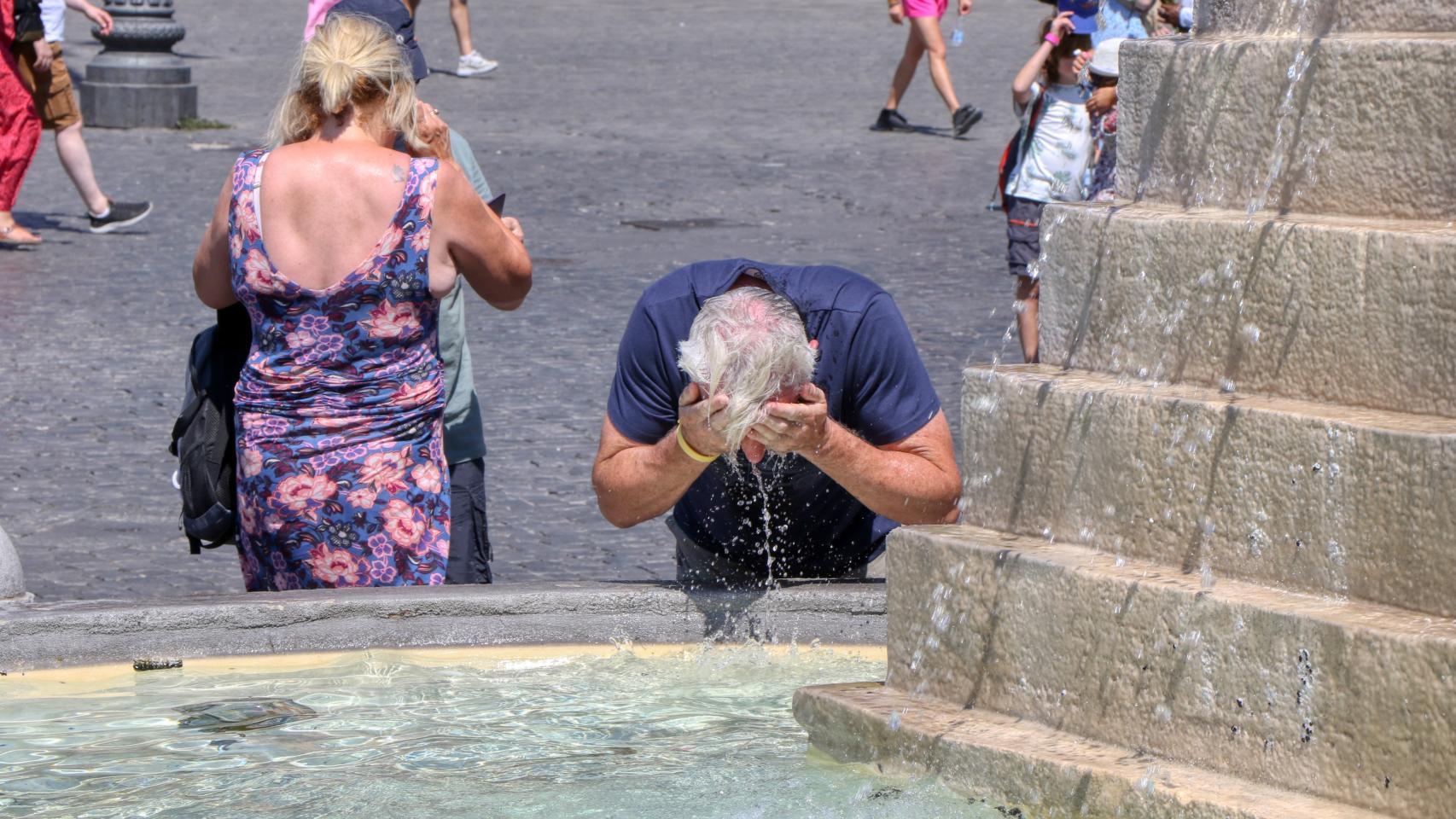 Dos personas se refrescan en una fuente de la calle, en una imagen de archivo.