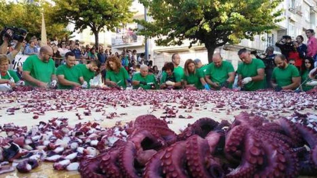 Participantes del festival cortando pulpo