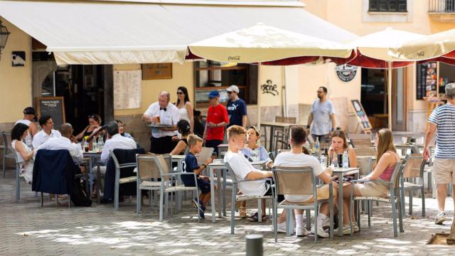 Varias personas en la terraza de un bar.