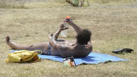 Un hombre toma el sol en la zona piscinas de Oira, en Ourense.