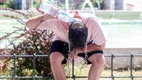 Una joven se refresca la cabeza con agua en Madrid.