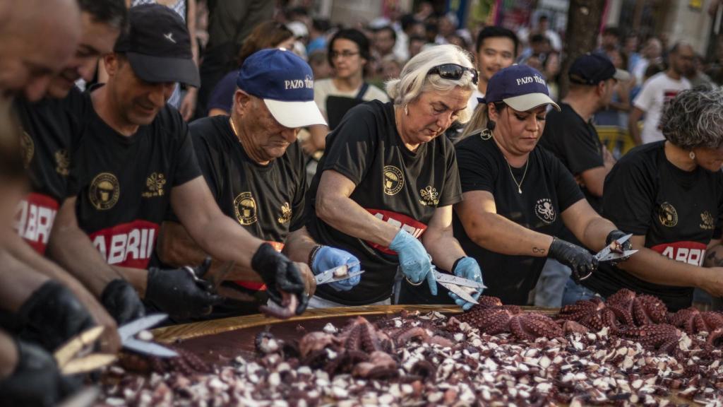 Pulpeiras y pulpeiros concentrados en la preparación de la tapa de pulpo más grande del mundo