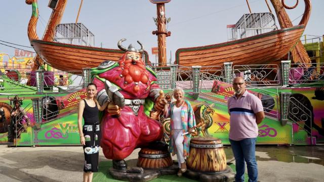 Elisa Pérez de Siles, Teresa Porras y Rafael Blánquez, junto a una de las atracciones de la Feria de Málaga.