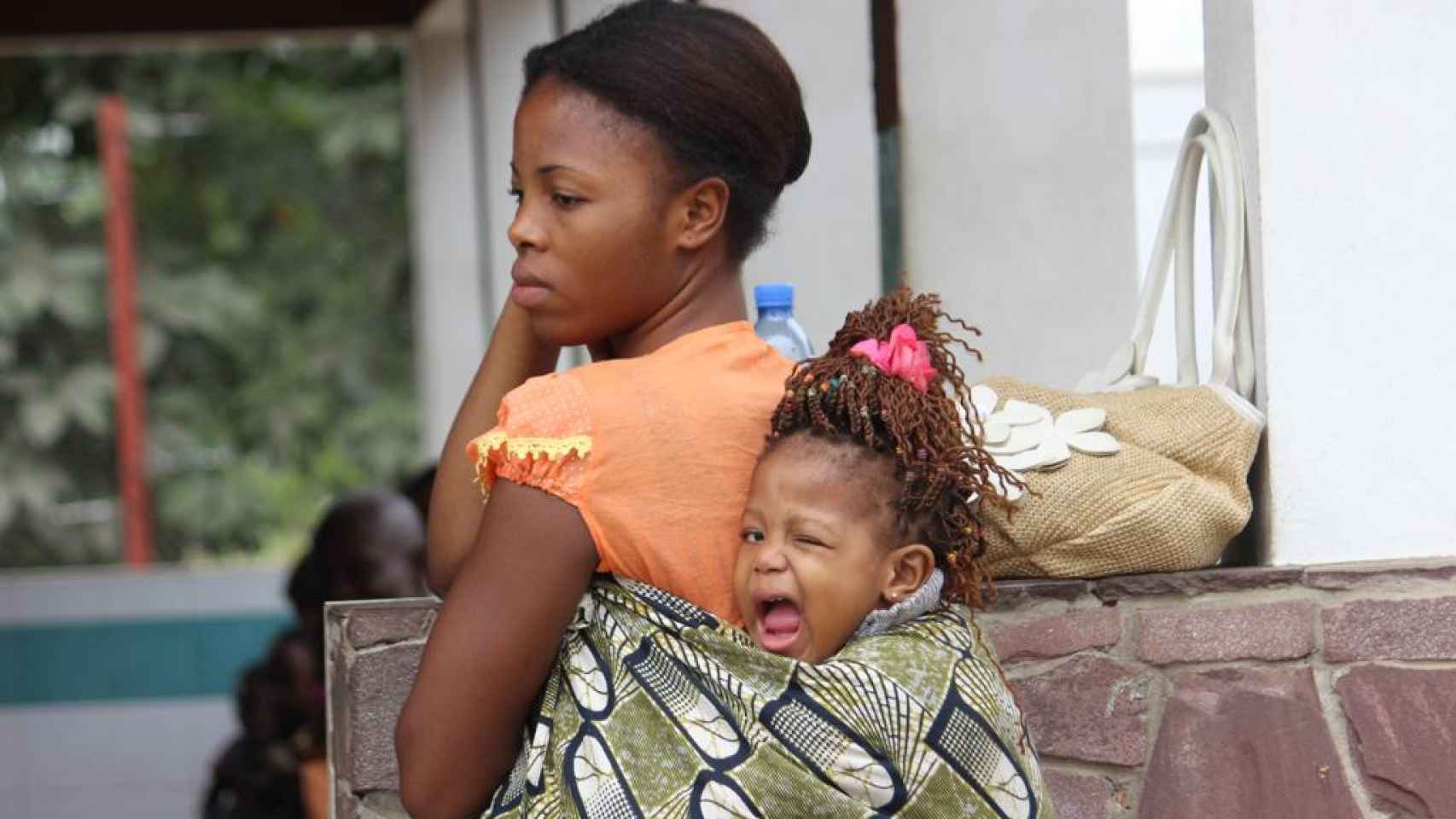 Una mujer lleva a su hija a cuestas en Kinsasa.