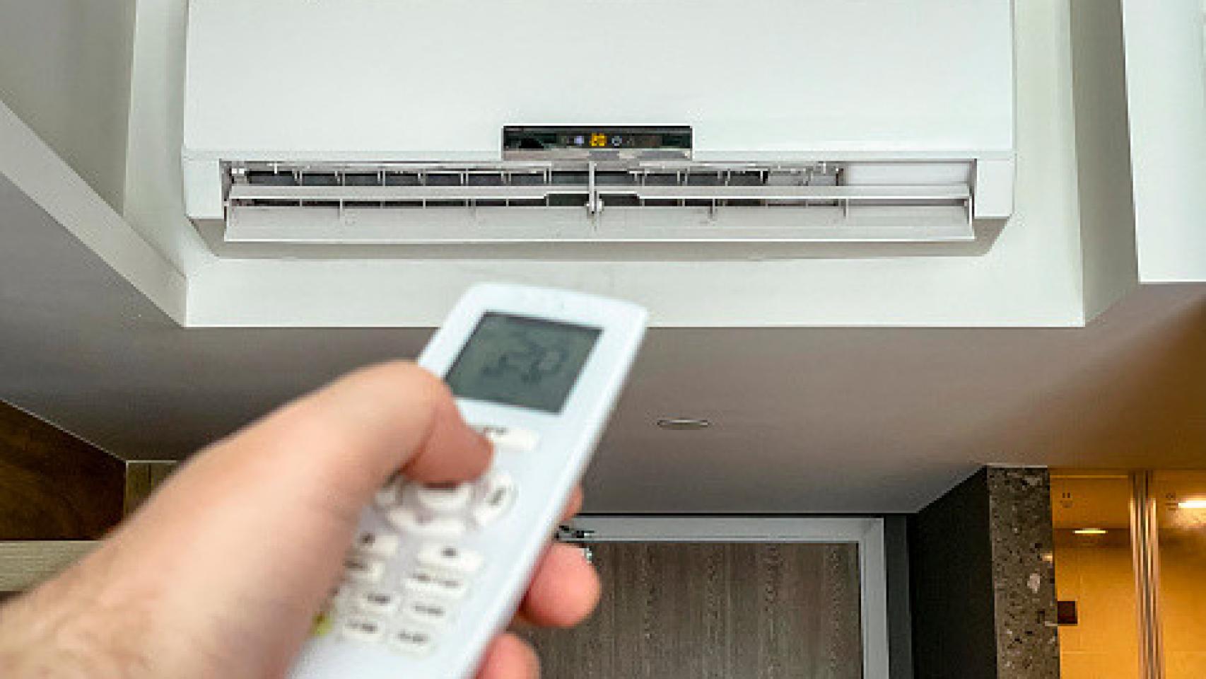Hombre configurando la temperatura del aire acondicionado. Foto: Getty Image.