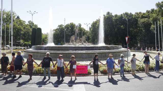 Un grupo de personas alrededor de la fuente de Neptuno, en Madrid.