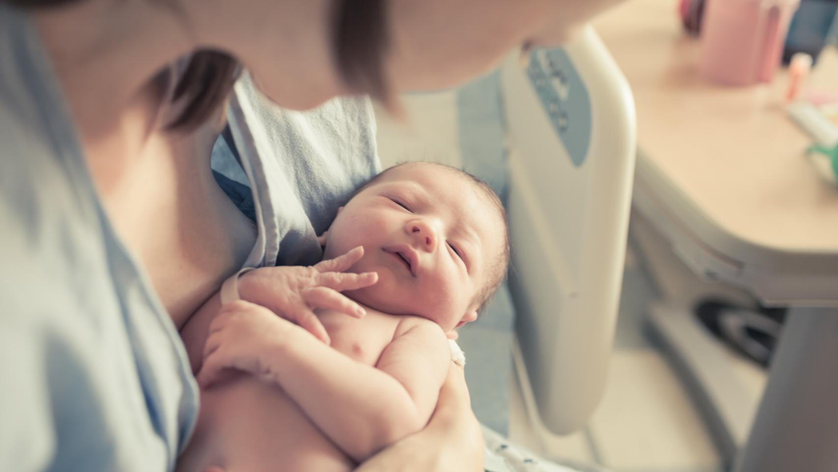 Una madre abraza a su hijo recién nacido en el hospital.