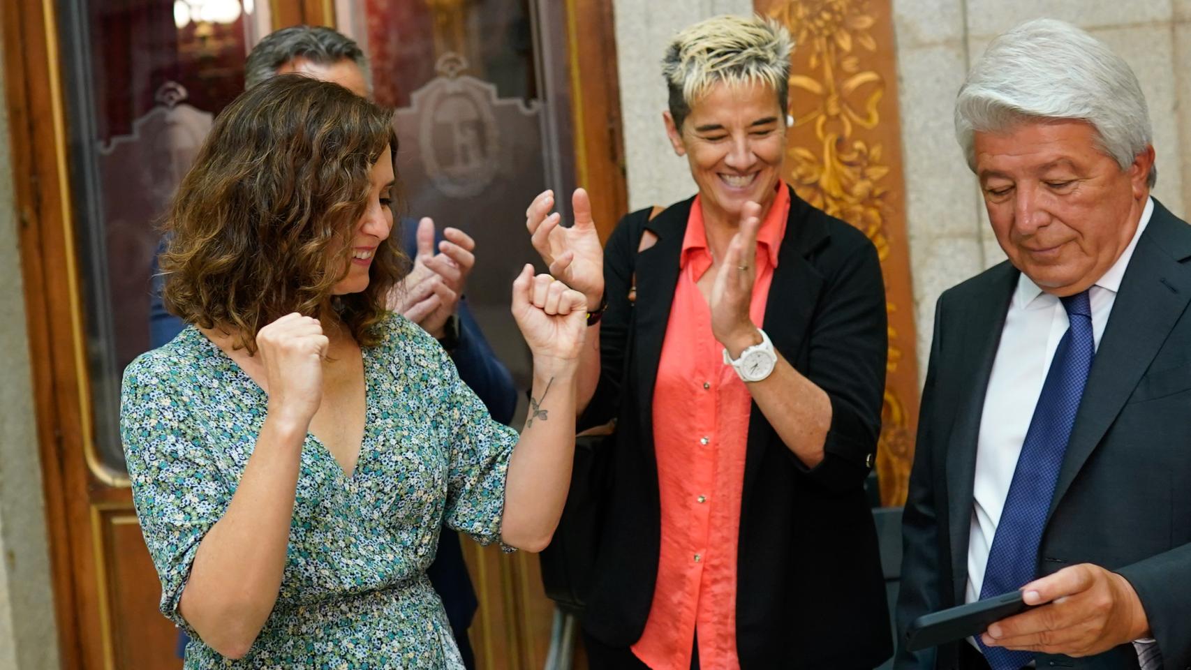 La presidenta de la Comunidad de Madrid, Isabel Díaz Ayuso; y Lola Romero, directora general del Atlético de Madrid Femenino, ven el final del partido en el móvil del presidente del Atlético de Madrid, Enrique Cerezo.