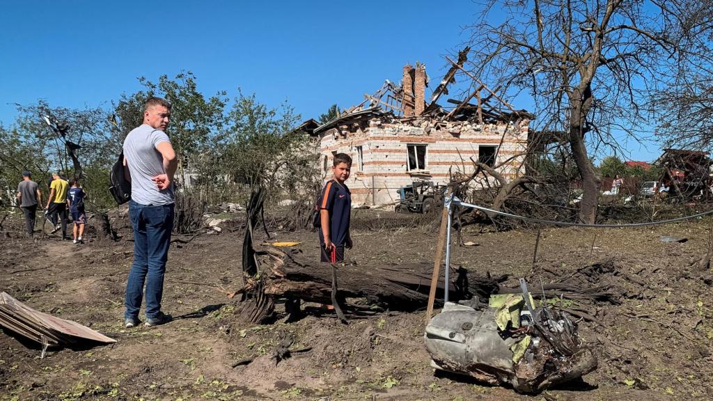 Dos ciudadanos junto a un trozo de misil caído en Leópolis