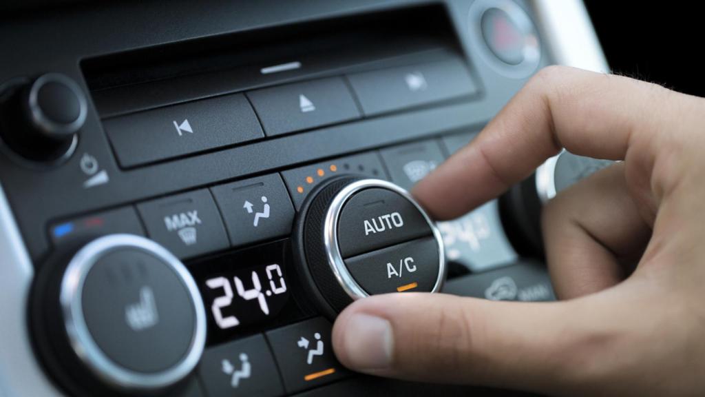 Imagen de archivo de una persona ajustando el aire acondicionado del coche.