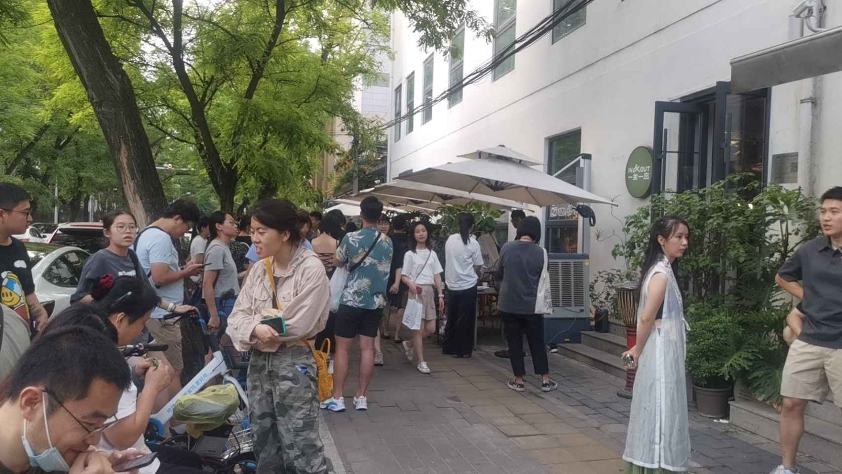 Personas haciendo cola a la salida del restaurante Yi Zuo Yi Wang.